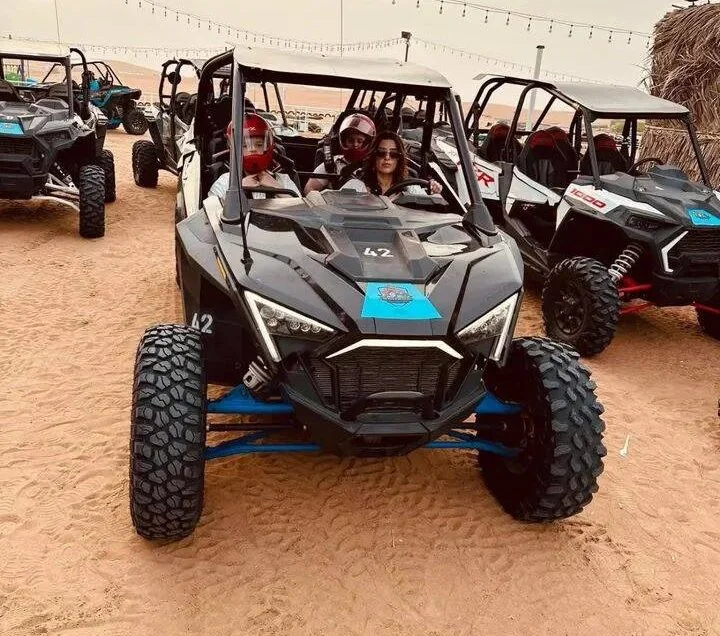 Polaris buggy driving across the Dubai desert dunes during an adventure tour